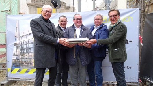 Grundsteinlegung-die-gefüllte-Zeitkapsel-vor-ihrer-Versenkung-in-das-Fundament